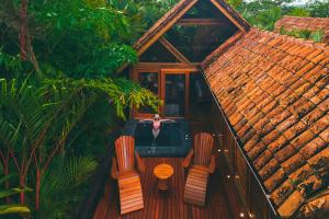 a house with a table and two chairs on a deck at Amor Arenal Adults Friendly in Fortuna