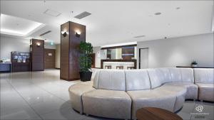 un soggiorno con divano e tavolo di Daiwa Roynet Hotel Hachinohe a Hachinohe