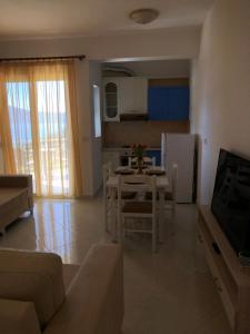 a kitchen and living room with a table and a refrigerator at Ions seaview apartments in Vlorë