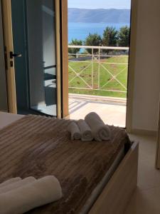 a room with a bed with towels and a sliding glass door at Ions seaview apartments in Vlorë +29 photos