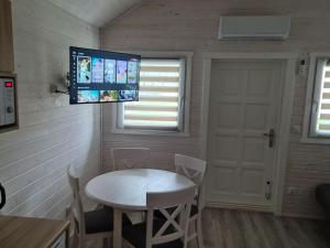 a room with a table and a tv on the wall at Comfortable holiday homes in Dziwnówek in Dziwnówek