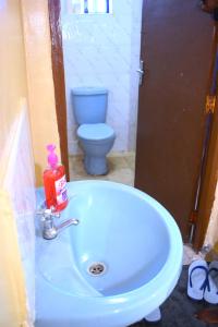 a bathroom with a white sink and a toilet at The Zen One Bedroom,Milimani, Nakuru in Nakuru