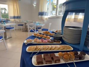 a table with several different types of pastries on it at Garden Hotel Alghero in Fertilia