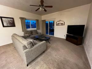 a living room with a couch and a flat screen tv at Canyon Plaza Premier Studio and Apartments in Tusayan