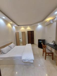 Un dormitorio con una gran cama blanca y un escritorio. en villa 3 apartment's, en Seis de Octubre