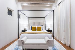 - une chambre avec un lit à baldaquin et une chaise dans l'établissement Casa Cielo, 4-Story Luxury Home with Rooftop Hot Tub & AC, à San Miguel de Allende