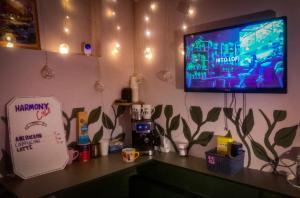 Harmony Boutique Hostel في باتومي: غرفة مع تلفزيون على جدار مع منضدة