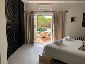 una camera con letto e porta di accesso a un patio di CASA DOS CATOS a Praia Verde