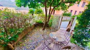 a patio with a table and chairs in a garden at Villa Iris in Casarza Ligure