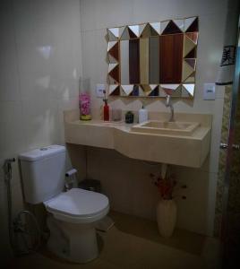 bagno con servizi igienici, lavandino e specchio di Residencial Celedone a Boa Vista