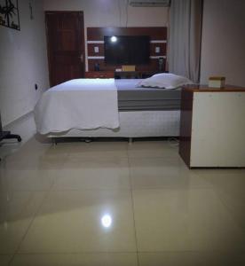 1 dormitorio con 1 cama y TV en Residencial Celedone en Boa Vista