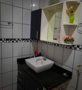 bagno con lavandino bianco e specchio di Residencial Celedone a Boa Vista