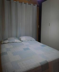 un letto con due cuscini in una camera da letto di Residencial Celedone a Boa Vista