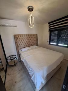 a bedroom with a large white bed with a chandelier at Vila Romantica in Budva