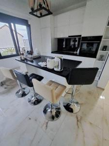 a kitchen with a black counter and chairs at Vila Romantica in Budva