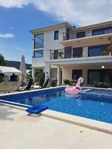 a large swimming pool in front of a house at Vila Romantica in Budva