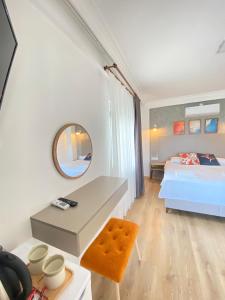 a bedroom with a bed and a desk and a mirror at MAVİ ROTA BUTİK OTEL in Datca