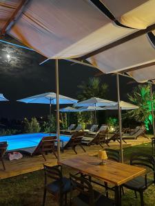 a patio with tables and umbrellas and a pool at MAVİ ROTA BUTİK OTEL in Datca