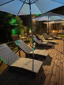 a group of lounge chairs and umbrellas on a deck at MAVİ ROTA BUTİK OTEL in Datca