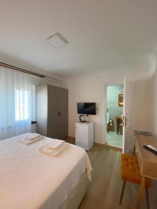 a bedroom with a large white bed and a desk at MAVİ ROTA BUTİK OTEL in Datca