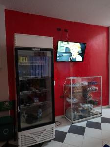 a refrigerator in a room with a tv on a wall at Hotel Daylin in Aguachica