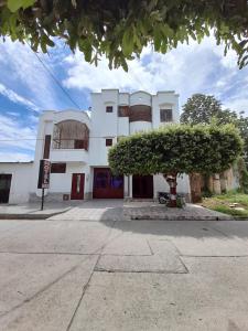 a white building with a tree in front of it at Hotel Daylin in Aguachica