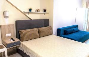 ネア・ミカニオーナにあるRoses Apartmentsのベッドルーム1室(ベッド1台、青い椅子付)