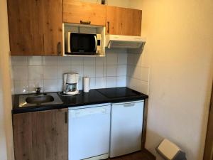 a small kitchen with a sink and a microwave at Résidence Hameau De Balestas Mp - T3/6pers JOUBARDE 01- Peyresourde MAE-1171 in Germ +2 photos