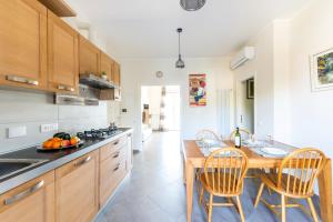 una cucina con armadi in legno, tavolo e sedie di Hostly-Family Home Ardenza-Near the seaside a Livorno