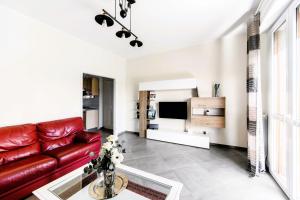 a living room with a red leather couch and a tv at Hostly-Family Home Ardenza-Near the seaside in Livorno