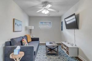 a living room with a couch and a flat screen tv at Amazing 1 BR apt - 1 block from Jax Beach! in Jacksonville Beach