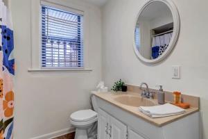 a bathroom with a sink and a mirror and a toilet at Amazing 1 BR apt - 1 block from Jax Beach! in Jacksonville Beach