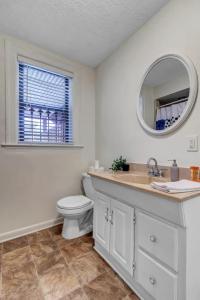 a bathroom with a sink and a toilet and a mirror at Amazing 1 BR apt - 1 block from Jax Beach! in Jacksonville Beach