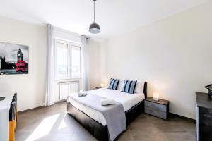 a bedroom with a bed and a large window at Hostly-Family Home Ardenza-Near the seaside in Livorno