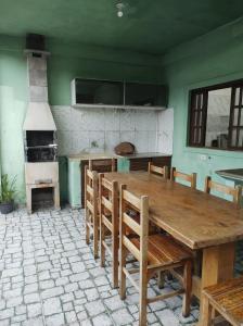 cocina con mesa de madera, sillas y horno en Recanto da Mara, en São Sebastião