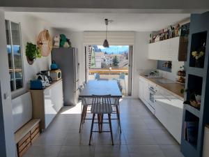 a kitchen with a table and some chairs in it at Calme à 2 pas du lac 3 chambres in Annecy