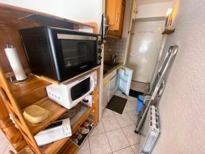 a small kitchen with a microwave and a refrigerator at Résidence Neouvielle - Studio dans le centre de Barèges proche du jardin MAE-5411 in Barèges