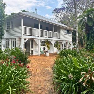 a large white house with a brick yard at Memory Lane Accommodation in Mount Tamborine