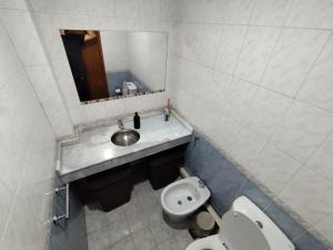 a bathroom with a sink and a toilet and a mirror at Chacras de Coria Los Robles in Chacras de Coria +29 photos