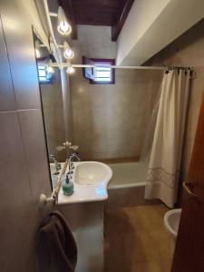 a bathroom with a sink and a shower and a mirror at Chacras de Coria Los Robles in Chacras de Coria