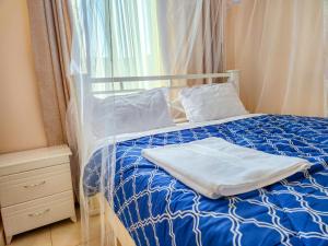 a bed with a blue comforter and white pillows at Luxury Suites in Seeta