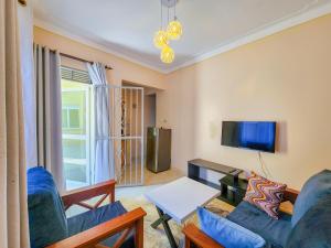a living room with blue furniture and a flat screen tv at Luxury Suites in Seeta