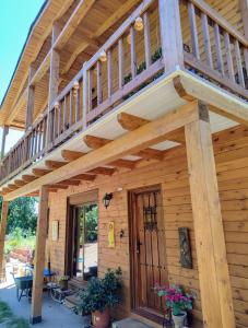 uma grande casa de madeira com um grande deque em Habitación simple con baño em Guadarrama