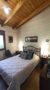 Un dormitorio con una cama grande en una habitación con techos de madera. en Habitación simple con baño, en Guadarrama