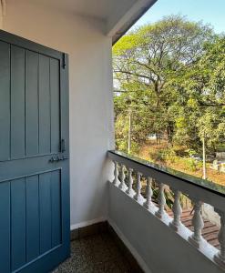 a door to a balcony with a window at Shenvi Homestay in Panaji