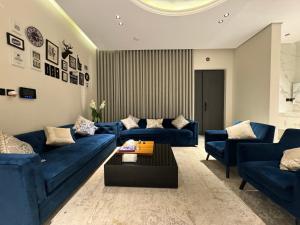 شقة ارضية ٣ غرف نوم وصالة ١ في الرياض: غرفة معيشة مع أرائك زرقاء وطاولة