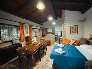 a bedroom with a bed and a table and a kitchen at Honey's Home-Dependance campagna in Villafranca