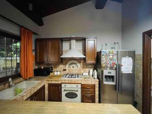a kitchen with a stove and a refrigerator at Honey's Home-Dependance campagna in Villafranca