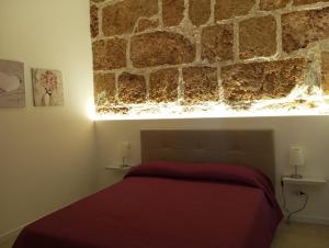 a bedroom with a stone wall above a bed at Holiday Home MATT ROS in Noto
