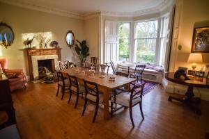 uma sala de jantar com uma mesa e cadeiras e uma lareira em Traditional Family Stone Farmhouse, sleeps 12, St Andrews em St. Andrews